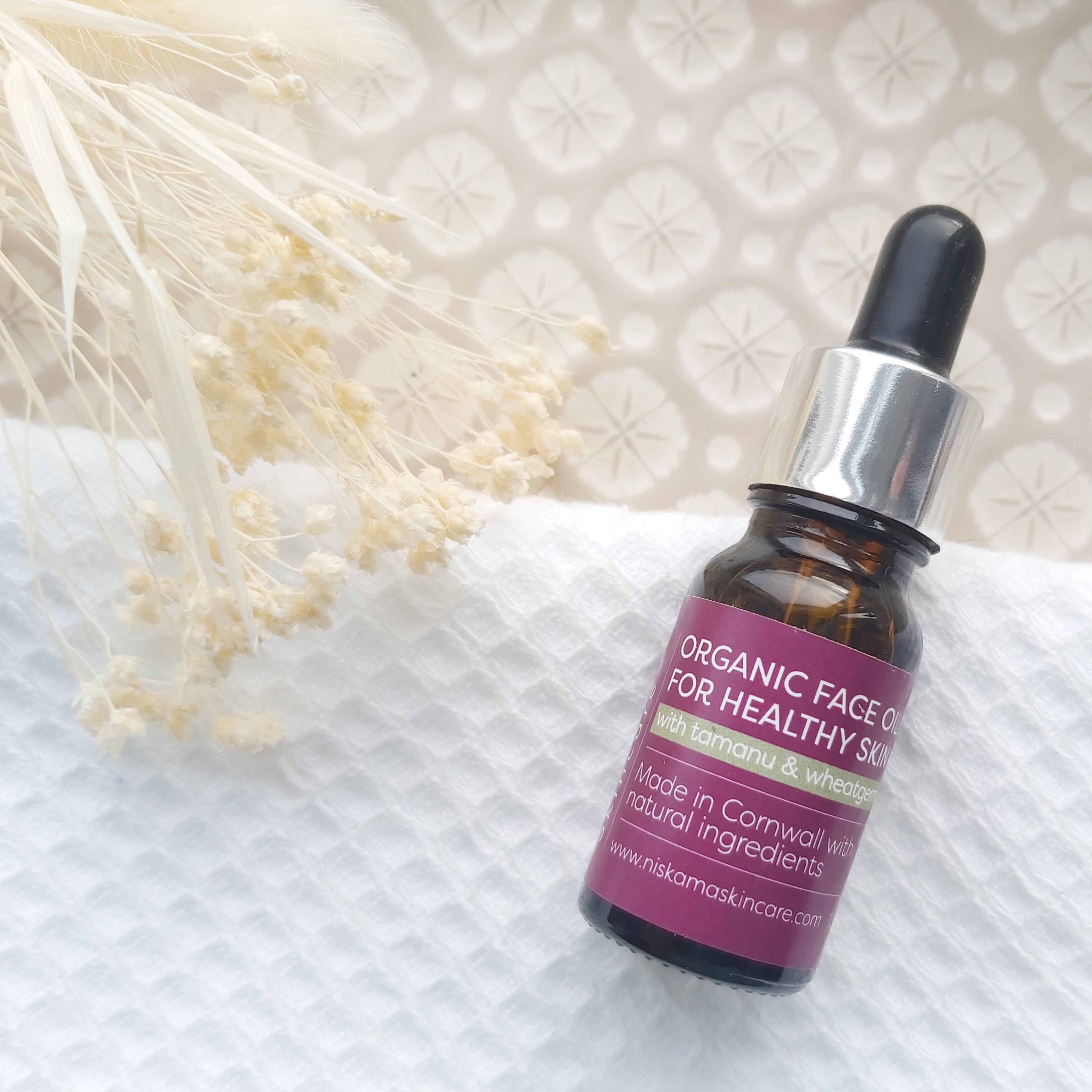 Niskama Skincare Organic Face Oil featured in The Natural Beauty Box May 2021 on a patterned plate, waffle white towel and natural foliage - Review by Beauty Folio