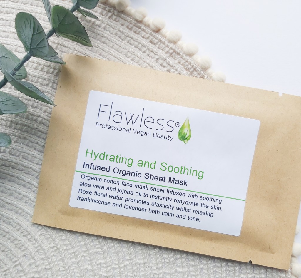 Flawless Organic Cotton Sheet Mask in its brown paper packaging on a beige place mat with pom pom edge and a eucalyptus stem. A Plastic Free Green Beauty Guide by Beauty Folio highlighting plastic pollution and plastic free beauty from Lovethical. 