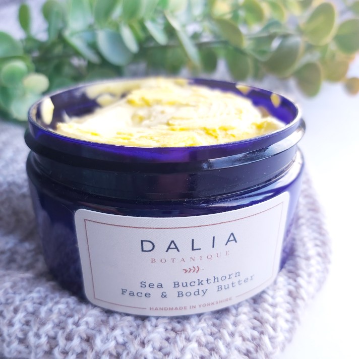 The Natural Beauty Box Replenish Box Dahlia Botanique Sea Buckthorn Face and Body Butter Jar open with autumn leaves and knitted throw - September Beauty Box - Review by Beauty Folio