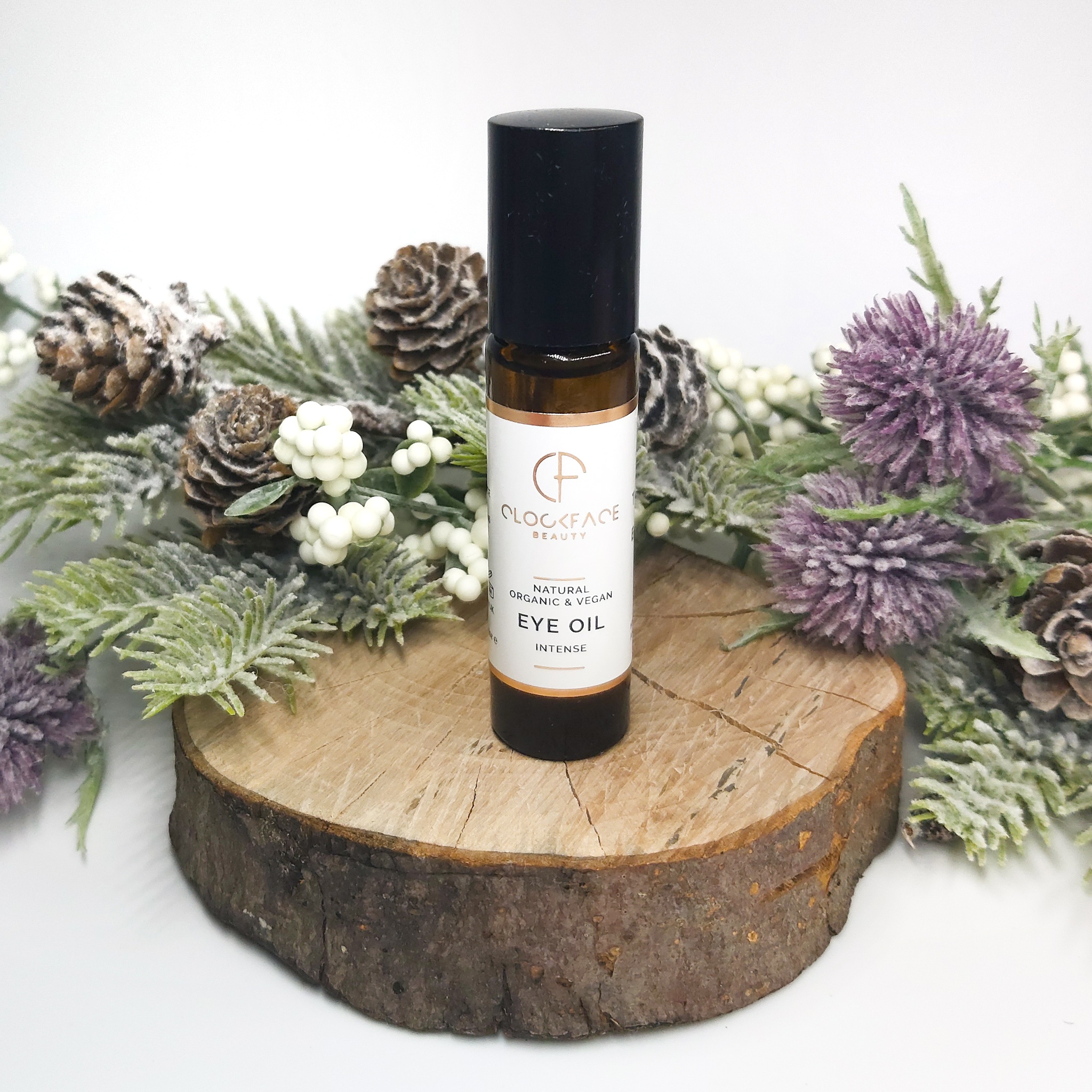 Clockface Beauty Intense Eye Oil on a log slice with Christmas foliage. Natural Beauty Christmas Gift Guide by Beauty Folio