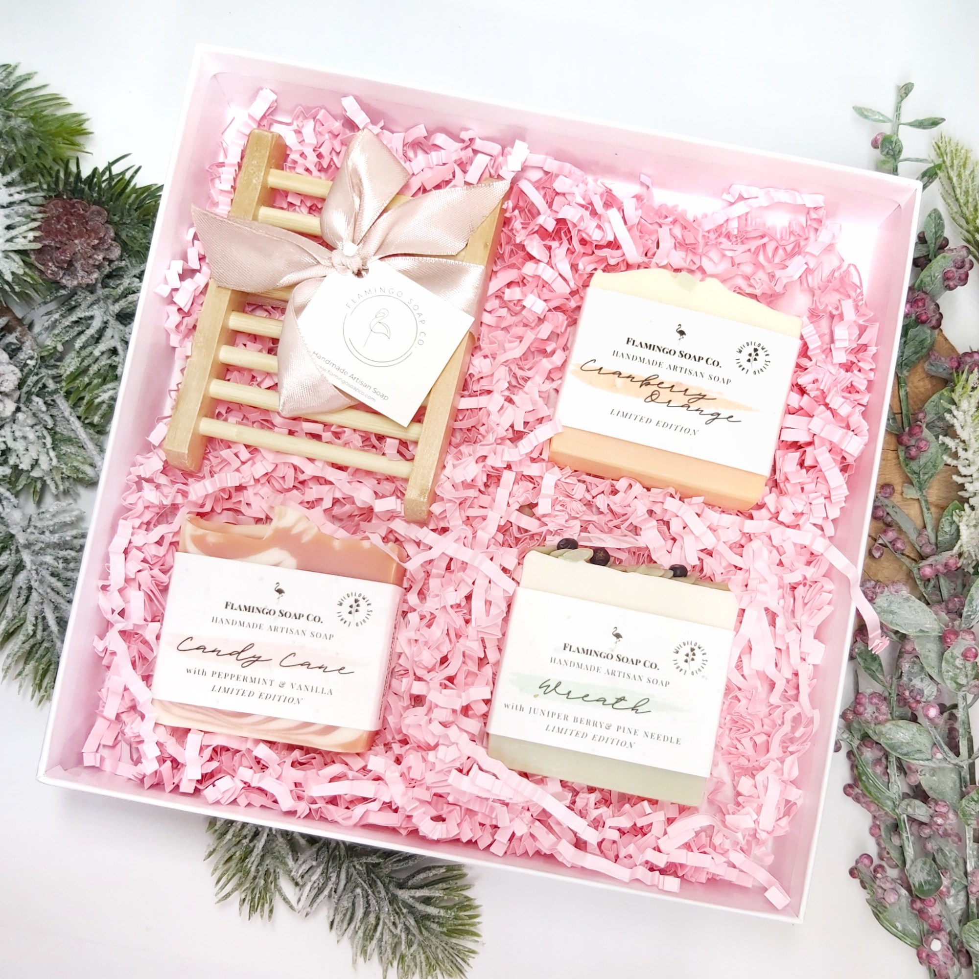 An open gift box with pink shredded paper with 3 bars and a wooden soap tray. Natural Beauty Christmas Gift Guide by Beauty Folio