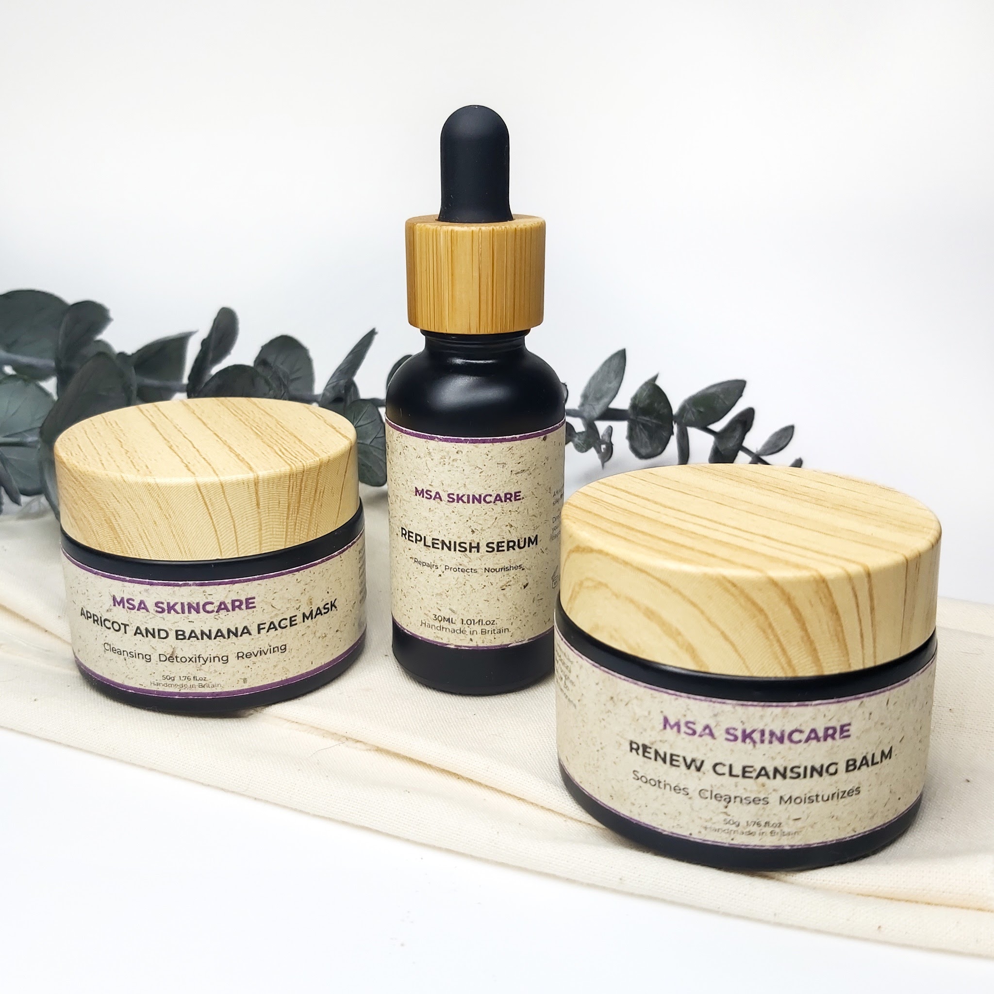 MSA Skincare products with a white background, sitting on top of linen fabric with a stem of eucalyptus stem in the background. Natural skincare review by Beauty Folio