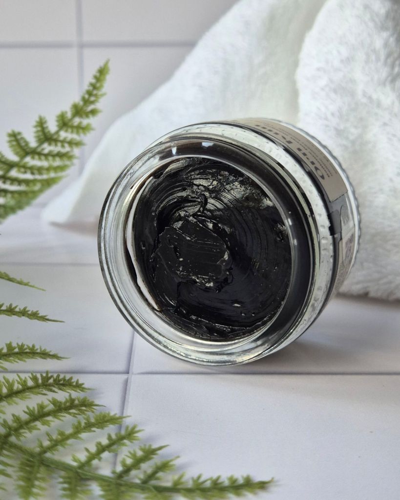 Õrn Kuu's Täht Radiance Forest Masque jar on it's side, sat on white tiles showing the dark mask texture - review by Beauty Folio