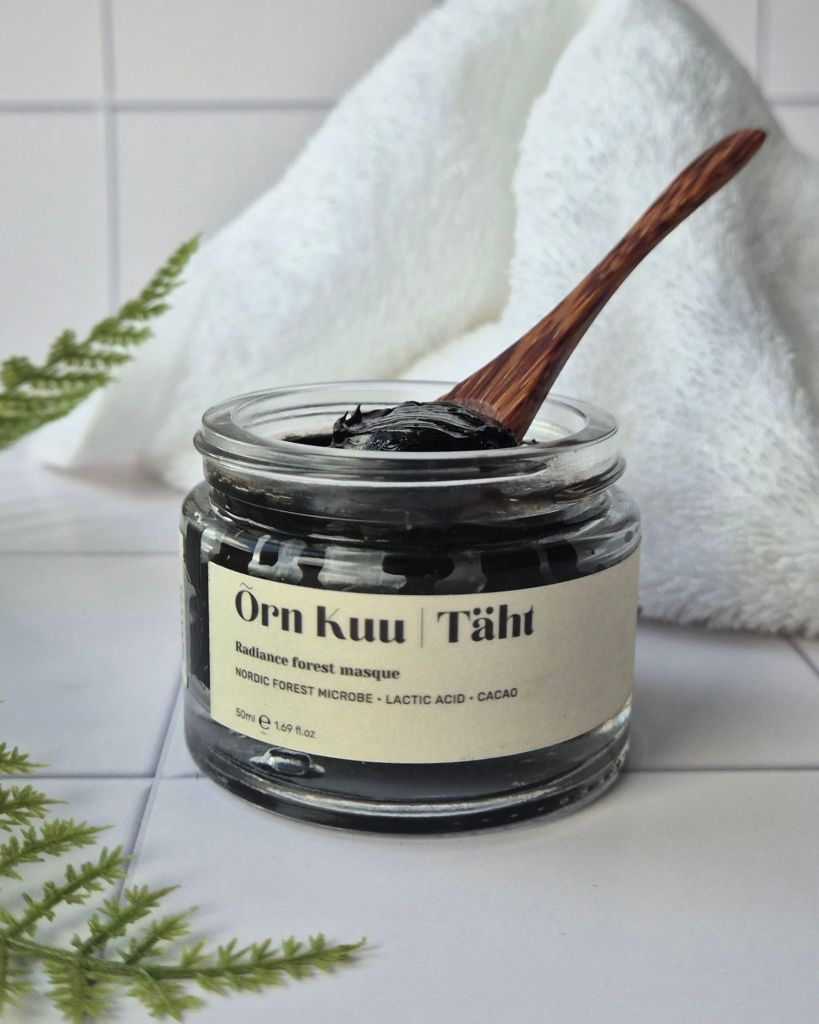 Õrn Kuu's Täht Radiance Forest Masque jar on white tiles with no lid, and a spoon in the jar with a little product on it - review by Beauty Folio